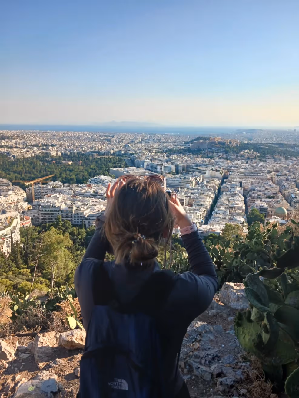 Guest photographing the Acropolis from the Lycabettus Hill trail above central Athens