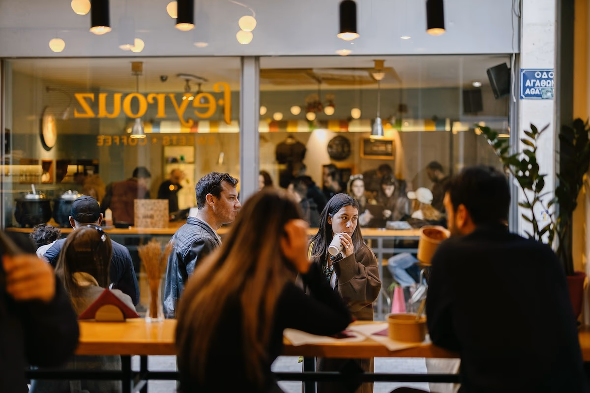 People enjoying coffee at a bustling Athens cafe