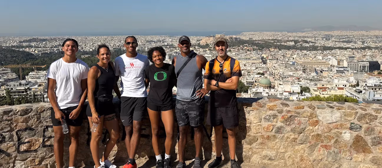 Small group on an Athens walking tour at a Lycabettus Hill viewpoint, the Acropolis and the city behind them