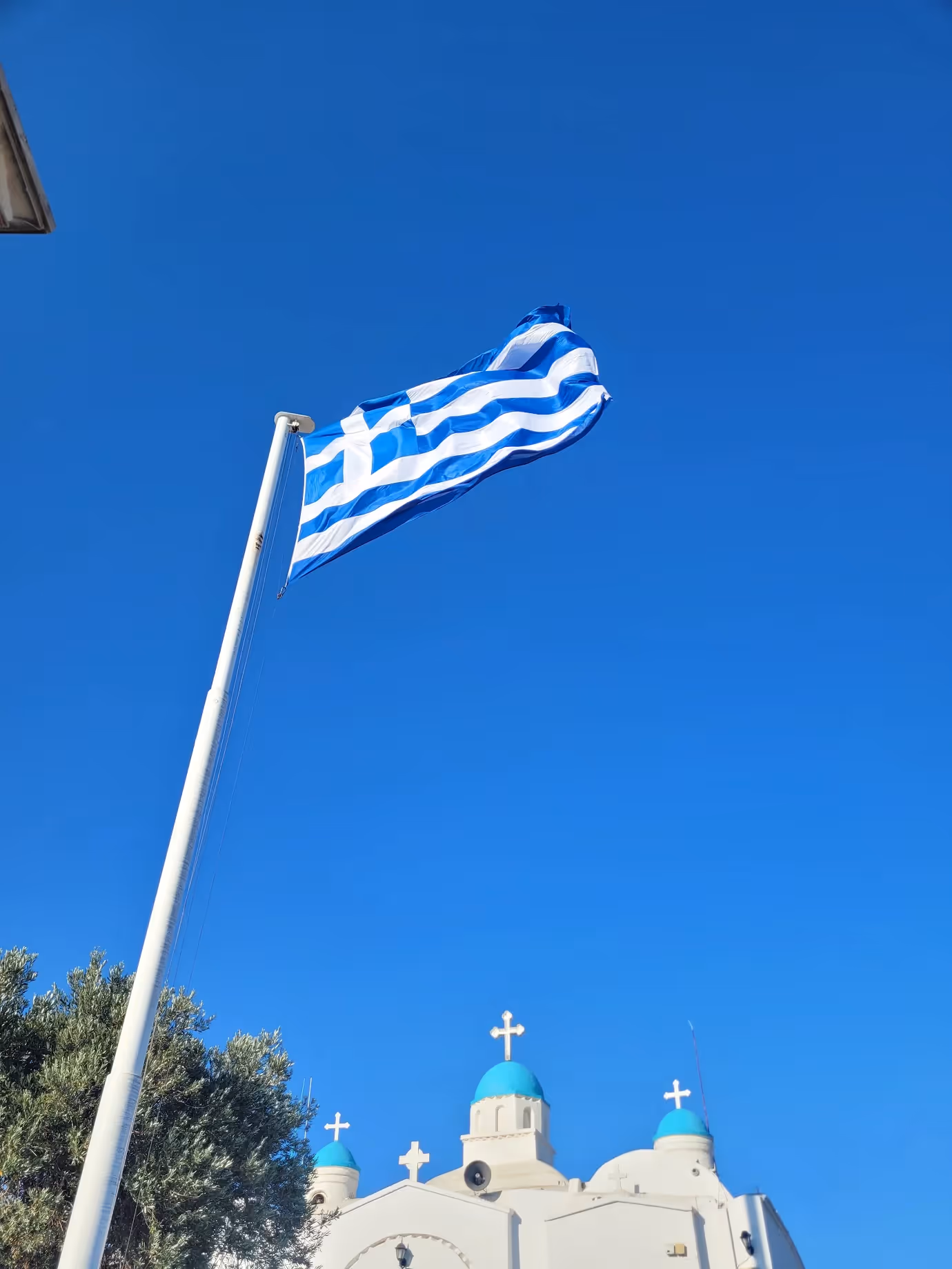 The chapel of St George and the Greek flag at the summit of Lycabettus Hill at dawn
