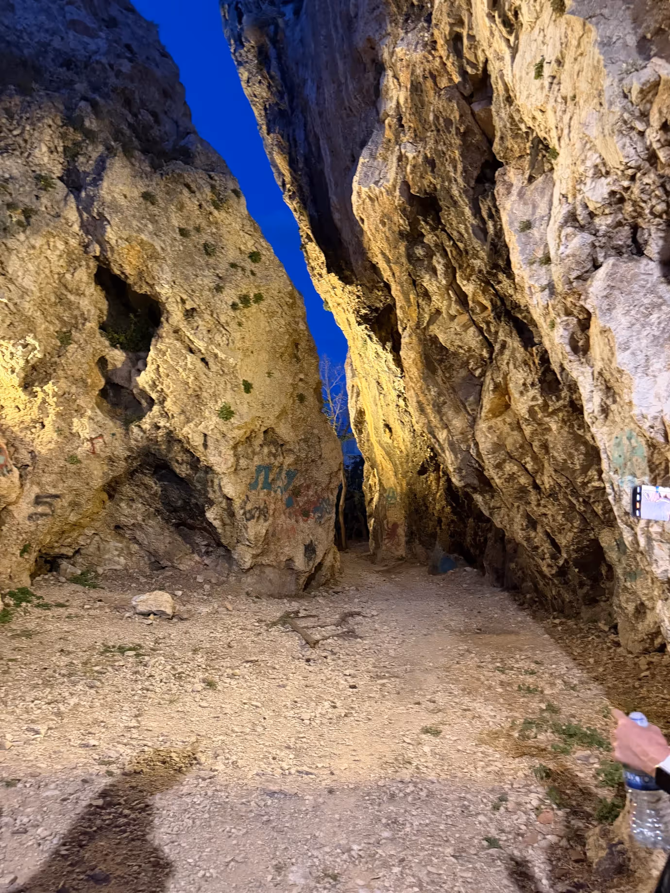 The Split Rock cleft on Lycabettus Hill lit at dusk, a hidden bouldering spot used by local climbers